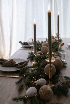 a table with candles, plates and napkins on it