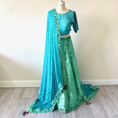 .Beautiful dupatta in a pure georgette turqoise fabric with sea green silk boarder with intricate hand embroidery  .Raw silk turquoise blouse with fully hand embroidered sleeves .Back of this unique backless design choli blouse in raw silk turqoise material .A unique custom made lahenga in sea green and turquoise raw silk material and georgette dupatta. All the work is fully hand embroidered . A vibrant raw silk lahenga in a turquoise and sea green colour with full hand embroidery Green Raw Silk Lehenga With Resham Embroidery, Green Raw Silk Choli With Dupatta, Green Art Silk Lehenga With Dori Work, Green Anarkali Raw Silk Choli, Green Lehenga With Dori Work In Art Silk, Green Dola Silk Lehenga With Resham Embroidery, Green Art Silk Lehenga With Resham Embroidery, Green Embroidered Raw Silk Lehenga, Embroidered Green Raw Silk Lehenga