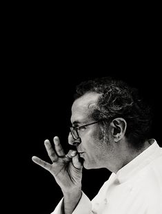 a black and white photo of a man with his hands in the air while talking