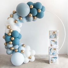 a balloon arch with blue and white balloons on the top is next to a box