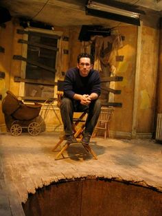 a man sitting on top of a wooden chair