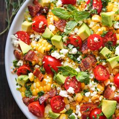 a salad with tomatoes, corn and avocado