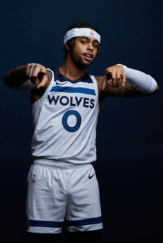 a man in a basketball uniform pointing at the camera with his right arm stretched out