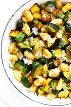 a white bowl filled with vegetables on top of a table