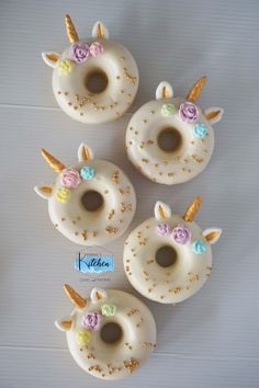 four doughnuts with unicorn ears and flowers on them