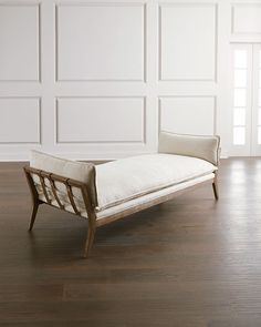 a white couch sitting on top of a hard wood floor next to a wooden door