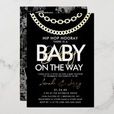 a black and white baby on the way card with gold chains hanging from it's sides