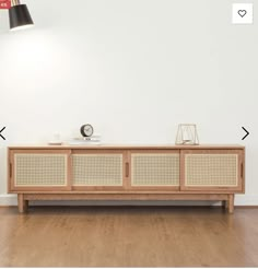 the sideboard is made out of wicker and has a lamp on top of it