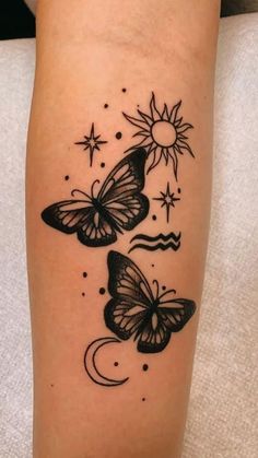 two butterflies with sun and moon tattoo on the arm