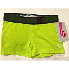 a pair of neon green shorts sitting on top of a white bed next to a tag