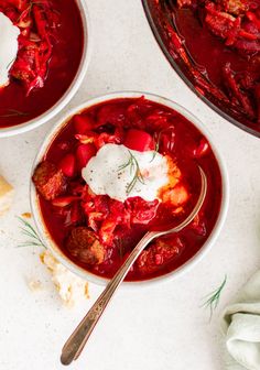 two bowls filled with stew and sour cream