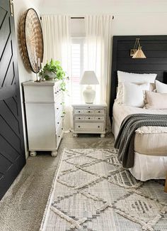 a bed room with a neatly made bed and a large rug on the floor next to it