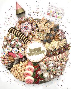 a large platter filled with lots of different types of donuts and other treats