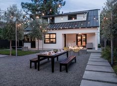 an outdoor dining area with table, benches and lights