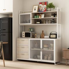 a kitchen area with a refrigerator, table and cabinets