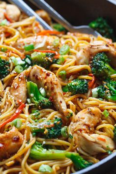 a pan filled with chicken, broccoli and noodles