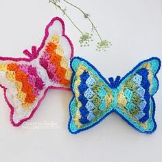 two crocheted butterflies sitting next to each other