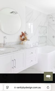 a bathroom with marble counter tops and white cabinets, along with a tub in the corner