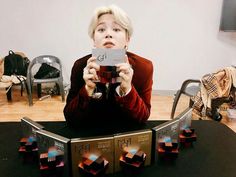 a woman taking a selfie in front of an array of cubes on a table