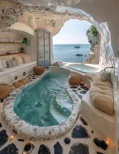 an indoor jacuzzi tub in the middle of a living room with ocean view