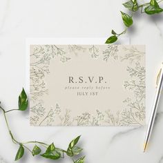 the wedding stationery is laid out on a marble table with greenery