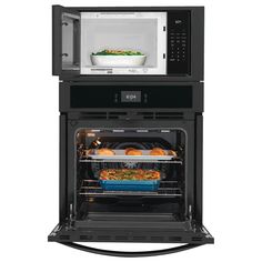 two microwave ovens with food in the door and one on the inside, both open