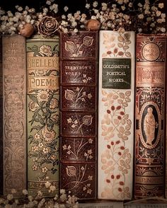 old books are lined up in a row with flowers on the front and back covers