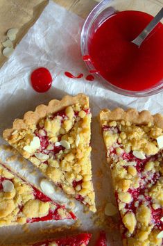 there is a piece of pie on the table next to a cup of juice and spoon