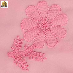 a pink piece of cloth with some flowers on the top and one flower in the middle