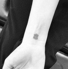 a woman's hand with a small tattoo on her left wrist and an eye in the middle