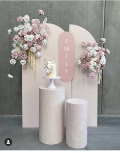 two white vases with flowers and a pink sign