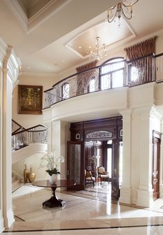 an elegant foyer with chandelier and marble flooring is seen in this image