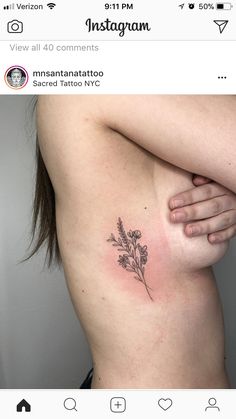 a woman's stomach with a small flower tattoo on her left side ribcage