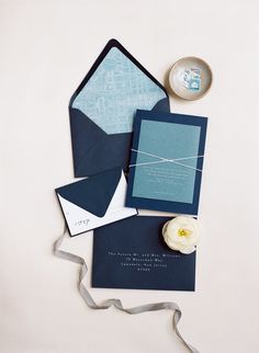 the wedding stationery is laid out on top of each other, including an envelope and ribbon