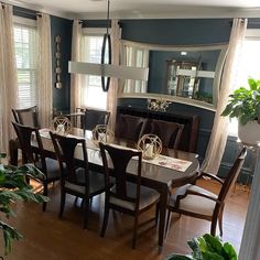 a dinning room table and chairs in front of windows