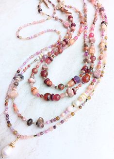 3 designs packed with rich jeweltone color. Mostly fushia, pink, copper, champagne, purples, some greens, and beige-gold. Tons of texture and interest. A variety of gemstones including Tourmaline, Citrine, Quartz, Sunstone, Jade, Fresh Water Pearls, Pyrite, Cracked Agate, faceted Czech beads, seed beads, and more in a variety of sizes, finish, and texture. First, this extra chunky double layer necklace. Made up of 2mm to 12mm pearls and gemstones. Longer layer is 22", shorter layer is 20". Strun Double Layer Necklace, Rose Quartz Necklace, Pink Necklace, Czech Beads, Citrine, Rose Quartz, Tourmaline, Freshwater Pearls, Opal