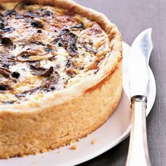 a close up of a pie on a plate with a knife and fork next to it