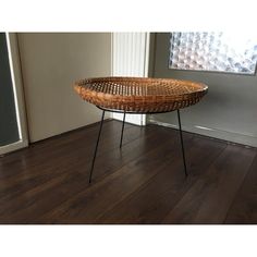 a wicker basket sitting on top of a wooden floor next to a window in an empty room