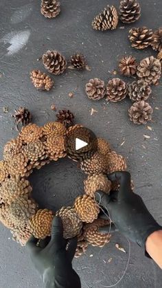 someone is making a wreath out of pine cones