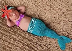 a baby is laying on the floor wearing a mermaid tail