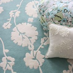 a blue and white flowered bed spread with two pillows