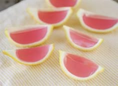 small pieces of fruit sitting on top of a white cloth covered in pink icing