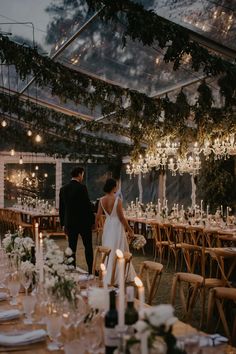 a bride and groom are standing in front of the reception tables