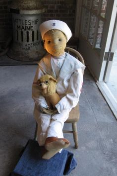 a teddy bear sitting on top of a chair with a stuffed animal in it's lap