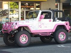 a pink and white jeep parked in front of a store