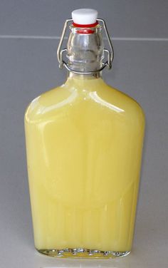 a glass bottle filled with yellow liquid sitting on top of a table