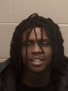 a young man with dreadlocks is looking at the camera while wearing a black shirt