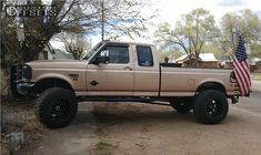 a tan truck with an american flag on the bed