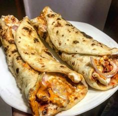 three quesadillas on a white plate with cheese and meat toppings, ready to be eaten