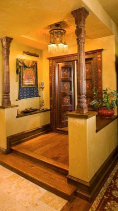 an entry way with wooden pillars and decorative artwork on the wall, along with hardwood flooring